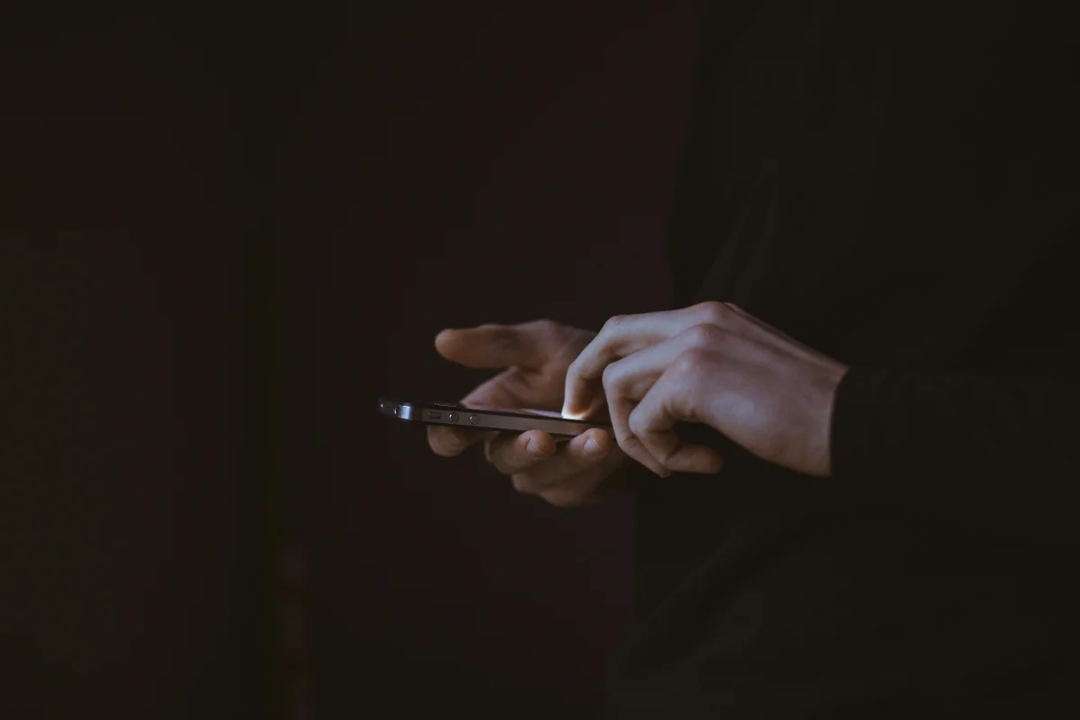 Beitragsbild: Hand legt Handy weg - Tisch, Tageslicht, ruhig