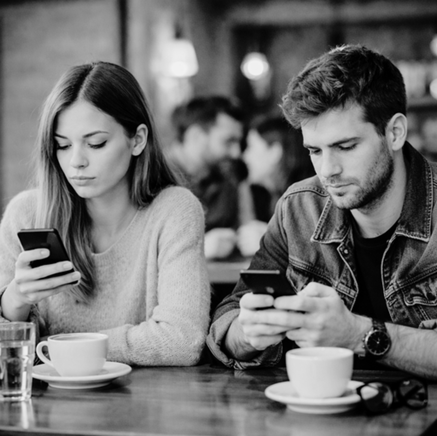 Paar im Café, beide schauen auf ihr Smartphone